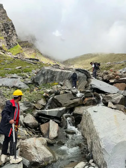 Navigating a rocky stream crossing on the way to Friendship Peak. The terrain is varied and challenging.