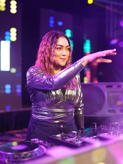 Reaching out to the crowd while keeping one hand on the mixer, always connected to both the music and the audience.