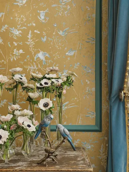 The enchanting Hummingbirds wallpaper creates a perfect backdrop for a curated display of flowers. This scene highlights how a detailed, nature-inspired wallcovering can complement and enhance the beauty of natural elements within a room.