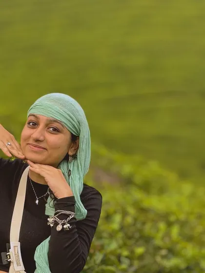 A portrait of a traveler amidst the green tea gardens of Munnar.