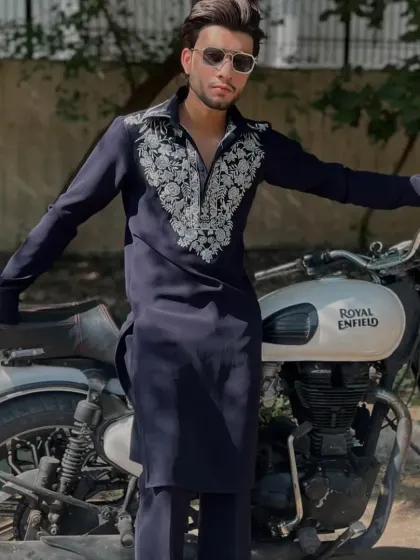 The navy blue kurta styled with a motorcycle for a cool, edgy look.