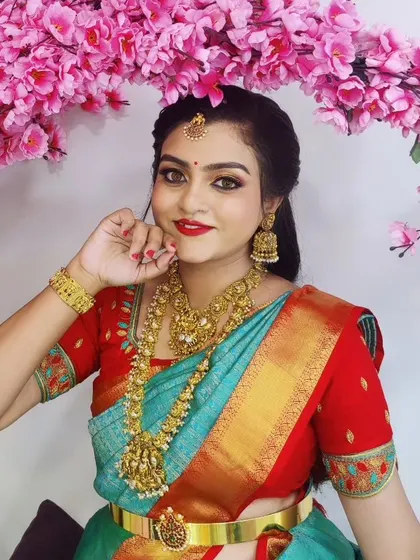 A beautiful studio-style shot of a client. The floral background complements her colourful saree and the classic, elegant makeup.