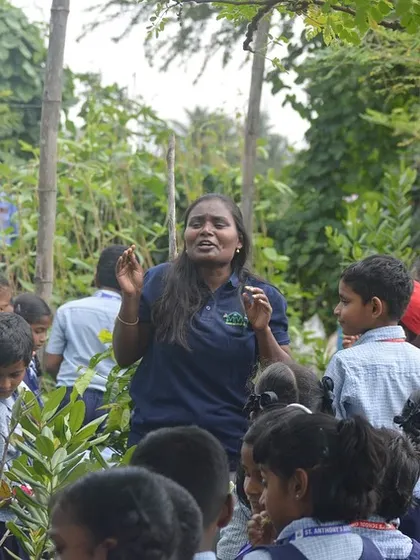 A lesson in the great outdoors. Our team member passionately explains the different types of plants and their unique characteristics to an engaged group of students during a school visit.