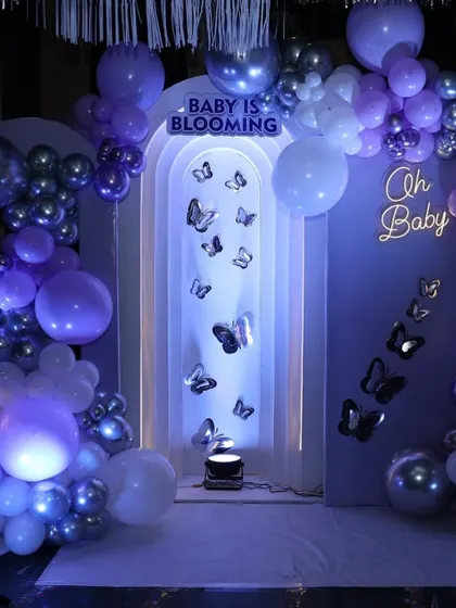A close-up of the butterfly decor, with a neon 'Oh Baby' sign and silver butterflies appearing to flutter up the wall.
