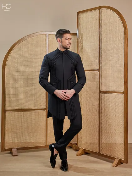 This embroidered achkan makes a definitive statement. The geometric embroidery and pleated fabric panels create a look that is both regal and fashion-forward.