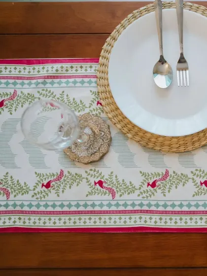 A close-up of a festive table setting featuring a table runner from our Rani Collection. The intricate print and vibrant colors instantly elevate the dining experience, making it perfect for celebrations.