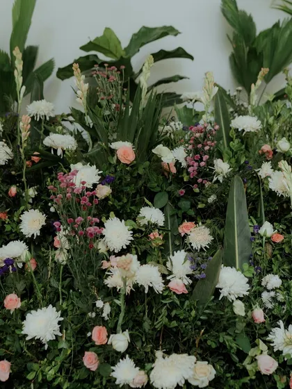 A close-up of a floral arrangement with a mix of white and pink flowers against a lush green background.
