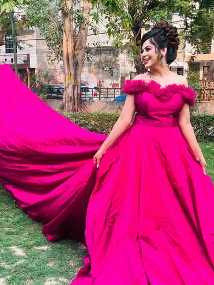 A vibrant magenta gown with a dramatic long trail, perfect for a pre-wedding shoot or a bold reception look.