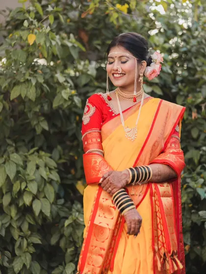 A joyful, candid portrait of the bride against a natural green background, capturing a moment of pure happiness.