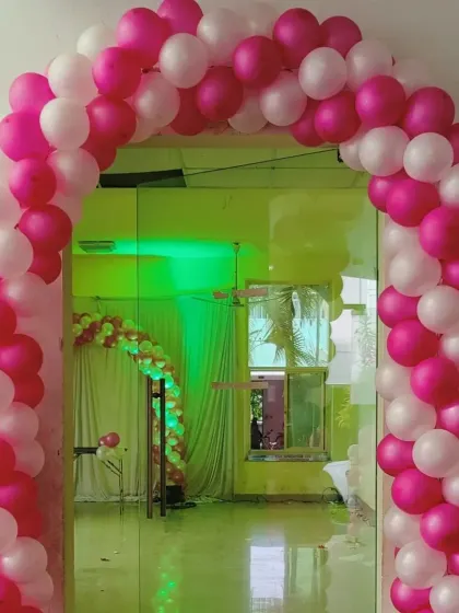 A simple and elegant pink and white balloon arch, perfect for an entrance to a baby girl's celebration.