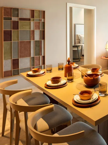 A dining table set for a meal, illustrating how we design spaces for living. The warm wood table, comfortable chairs, and geometric art piece create an inviting atmosphere for sharing food and making memories.