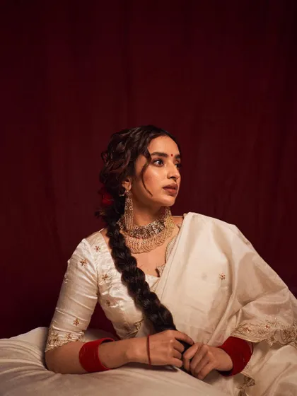 A serene and classic portrait. The model's thoughtful expression and the traditional styling evoke a sense of calm and timeless elegance, reminiscent of vintage Indian portraiture.