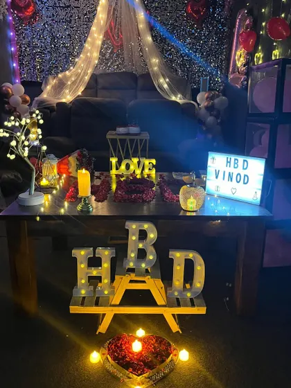 A detailed look at one of our romantic birthday setups. It features a canopy, fairy lights, a personalized lightbox, and 'HBD' marquee letters.