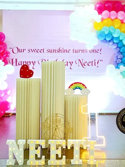 A "sweet sunshine" party for Neeti's first birthday, featuring a beautiful balloon rainbow and fluffy balloon clouds.