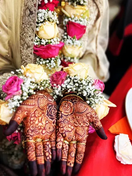 A beautiful shot of an engagement ceremony, with the bride's hands adorned with floral jewelry and my henna design.
