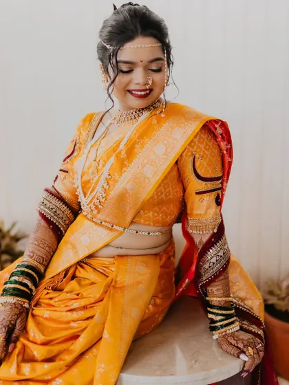 A seated portrait of the bride, showcasing the full elegance of her Nauvari saree.