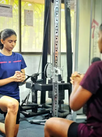 A player focuses on her form during a cable machine exercise, building core strength and rotational power.