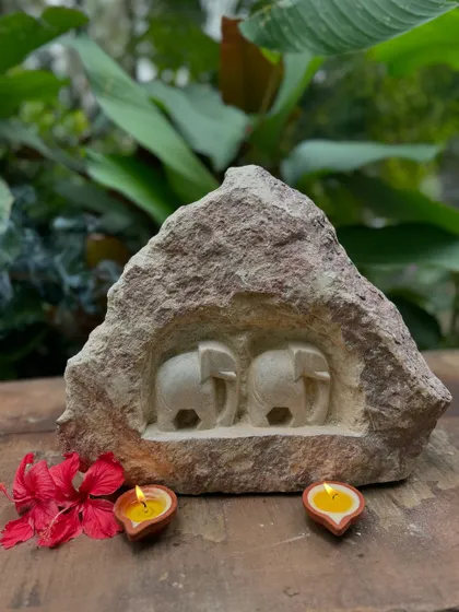 A pair of small elephants carved into a natural rock niche. Each stone is carefully selected, and the carving reveals just a portion of the story, retaining the rustic originality of the rock.