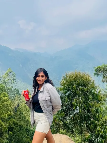 A traveler enjoying the breathtaking views of the Kodaikanal hills on a clear day.