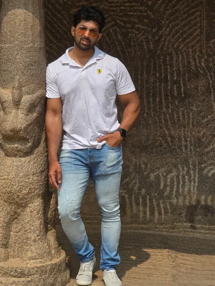 Leaning against a pillar inside a rock-cut cave, showcasing the raw and timeless beauty of Mahabalipuram's monuments.