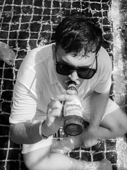 A candid black and white shot of a guest relaxing in the pool, capturing the casual and fun atmosphere.