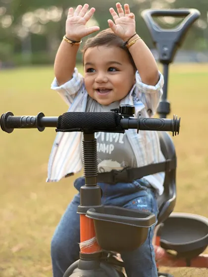 Hands up if you're having fun! An adorable and energetic shot of the little boy on his tricycle.