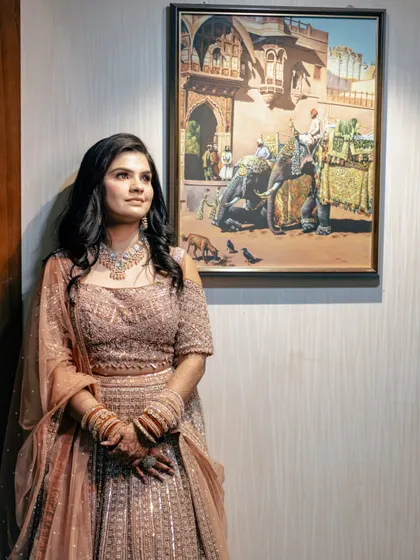A thoughtful portrait of the bride in a beautiful pastel lehenga. The soft lighting and artistic background create a feeling of serene elegance.