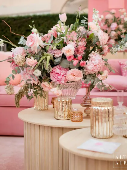 A close-up of a floral arrangement at the 'Echoes of Pink' wedding in Doha. The soft pinks and wooden tables created a beautiful contrast against the modern architecture of the venue.