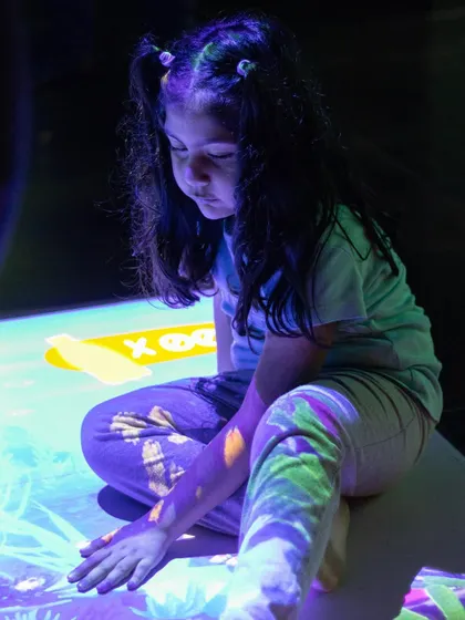 The interactive floor projects a beautiful, glowing garden that this little one is carefully exploring.