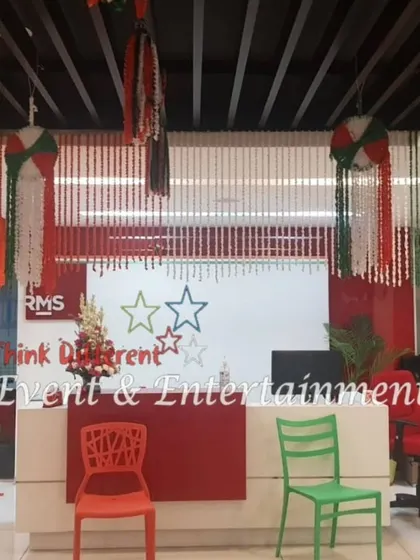 The reception desk of an office decorated with hanging floral balls and garlands in the colors of the Indian flag. Even small details can contribute to a festive and patriotic theme.