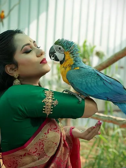 A unique and colorful portrait featuring a model with a beautiful blue and yellow macaw. This type of creative shoot is perfect for building a memorable portfolio.