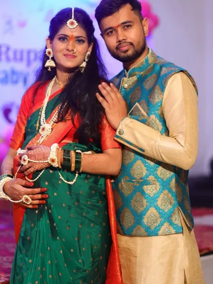 A sweet portrait of the expecting couple. Her jewellery set includes a maang tikka, necklace, earrings, and hathphool.