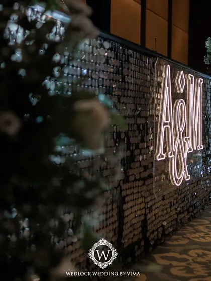 A custom-lit monogram for the couple, used as a focal point on the bar front. This personalized detail adds a modern and stylish touch to any celebration.
