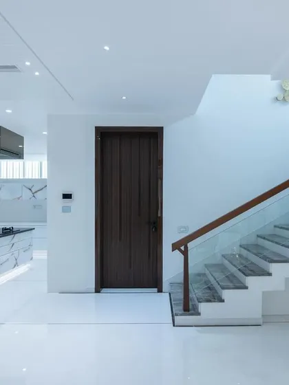 Simplicity is the ultimate form of sophistication. This all-white interior with a marble-clad kitchen island and a simple staircase is a study in modern elegance.