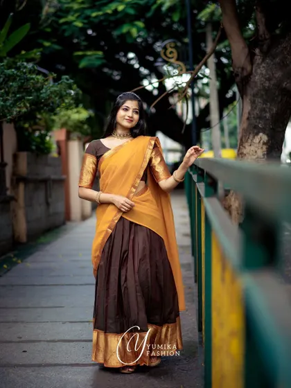 This Kanchi cotton half-saree in brown and mustard is perfect for a rustic, earthy look. The full outfit is shown here, highlighting the beautiful drape and color combination.