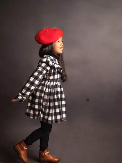 A candid, side-profile shot capturing her joyful expression as she walks through the frame, full of life and energy.