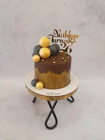 Another angle of the chocolate and gold decadence cake, showing off the metallic sheen and custom topper.