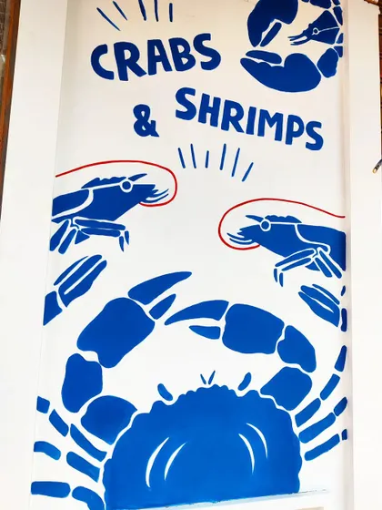 Bold, graphic illustrations of crabs and shrimps for a seafood restaurant's exterior. The clean lines and simple color palette create a strong visual identity.