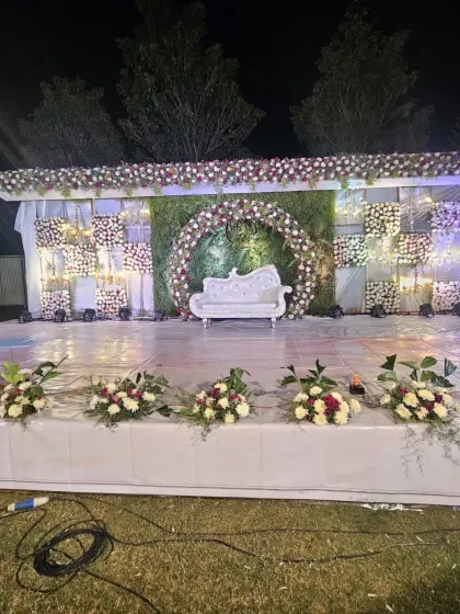 A wider angle of the outdoor reception stage, showing the scale of the setup and the professional lighting equipment used to illuminate the space at night.