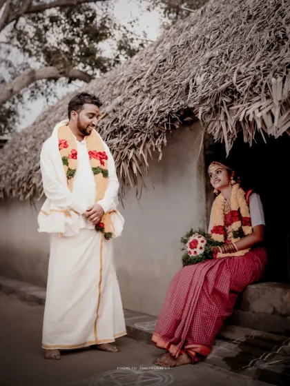 A charming portrait of the couple in a rustic village setting, showcasing a unique and traditional wedding photoshoot.