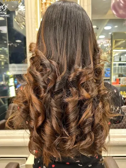 The final result of a stunning highlight service. The curls are full of bounce and show off the beautiful new color perfectly.