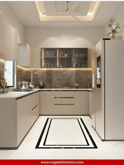 A clean and contemporary U-shaped kitchen in a soft beige. The design includes integrated appliances and glass-front cabinets. A decorative floor pattern adds a unique touch to the minimalist aesthetic.