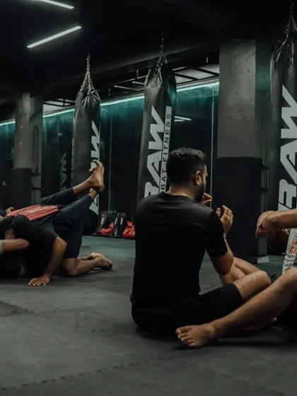 Students sit and discuss techniques after a tough round of grappling.