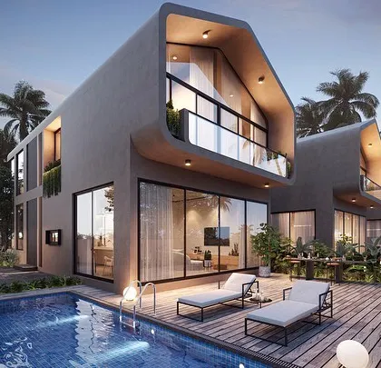 A poolside view of the Vagator Villas. The design features a distinctive sloping roof and a double-height window, creating an interior that is filled with light and visually connected to the pool deck and surrounding landscape.