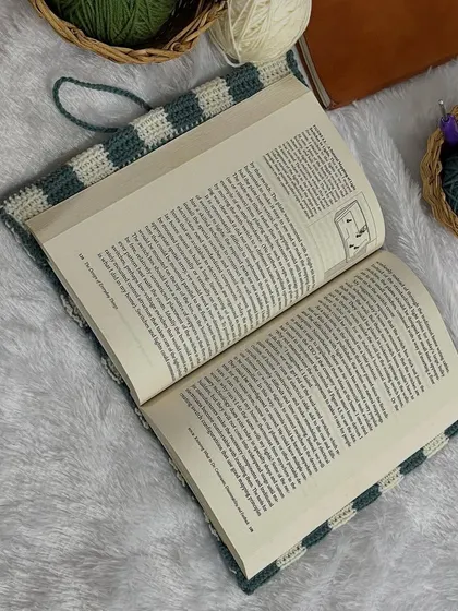 My crochet cover on an open book. It protects the cover and spine while you're reading.