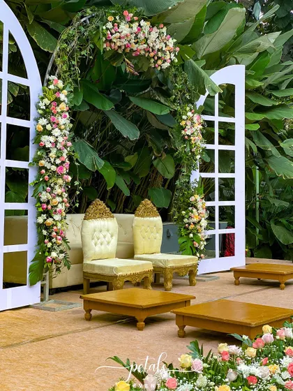 This engagement backdrop is a tropical dream, with a stunning flower arch of pastel roses and lush monstera leaves. The elegant seating completes the romantic and blissful setting.