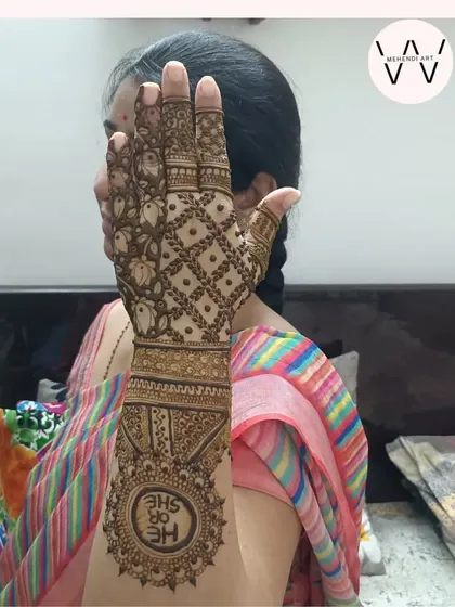 A happy mom-to-be showing off her "He or She" themed baby shower henna.