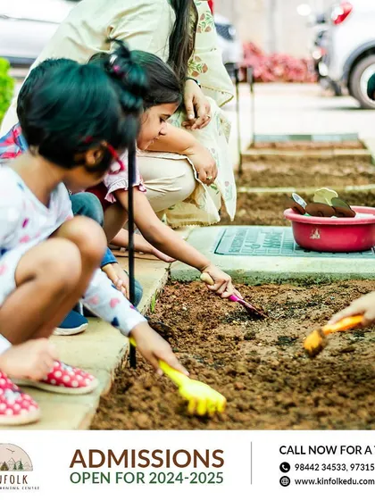 A group of children work together in the garden, using small tools to tend to the soil. This collaborative activity fosters teamwork and a shared sense of purpose.