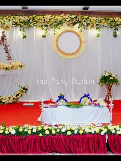 For Sharaag's naming ceremony, I created this traditional and elegant stage decor. The setup features a beautiful floral crescent moon for the baby's cradle, white drapes, and fresh flower arrangements, blending tradition with style.