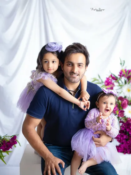 A proud father with his two daughters. This portrait captures the special bond a dad shares with his girls, filled with love and playfulness.